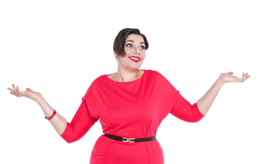 Beautiful plus size woman in red dress shrugs her shoulders isolated