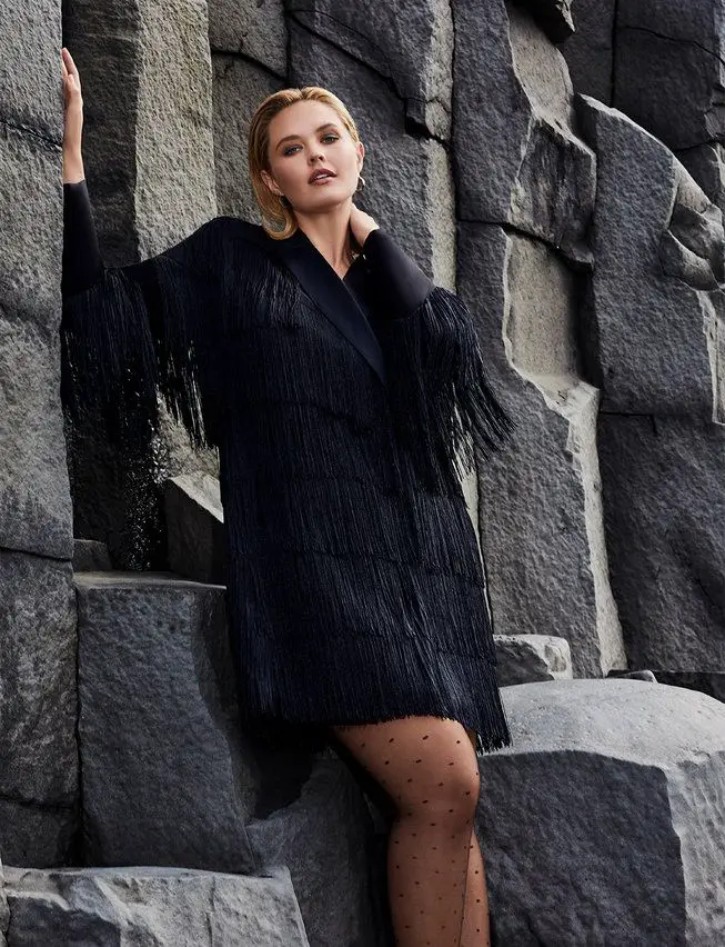 A woman standing in a Plus Size Fringe Blazer Dress from Eloquii 