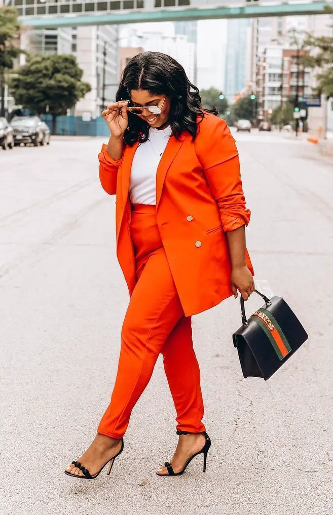 woman wearing a bright orange pantsuit with matching blazer posing in front of camera. with the street in the background.

12 Timeless Classics That Will Never Go Out of Style