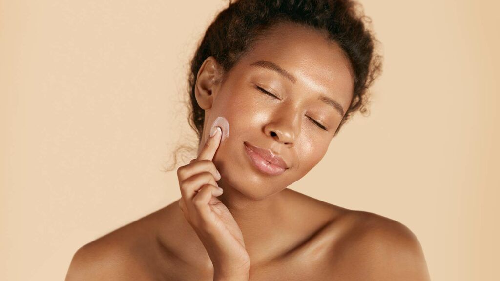 Woman applying moisturizer to her face