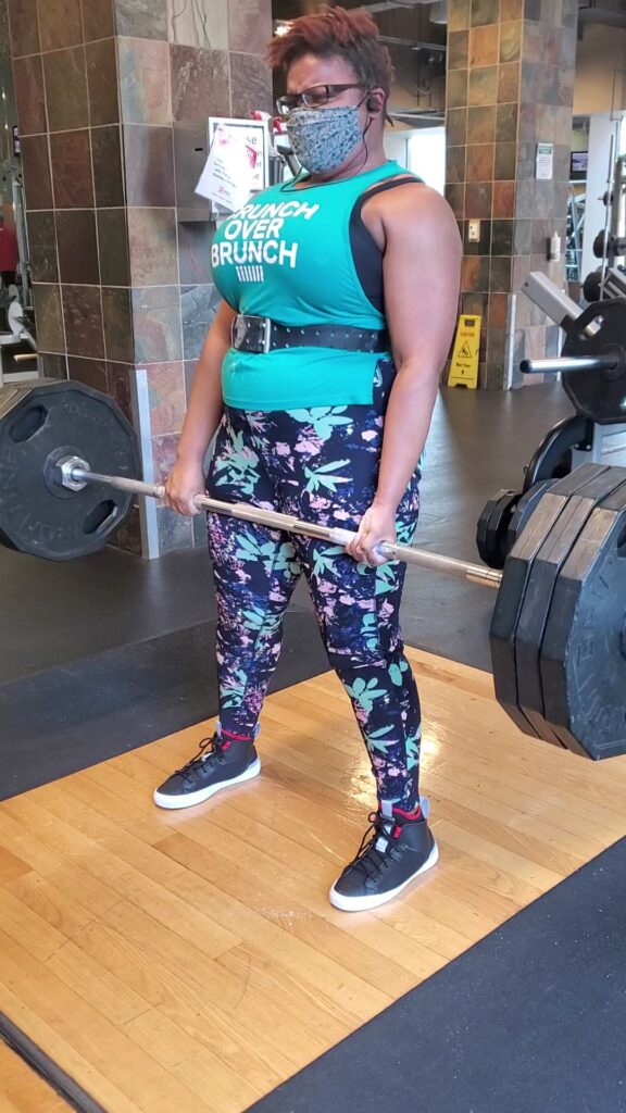 Carol wearing a Panache Sport Bra while lifting a barbell in a gym setting