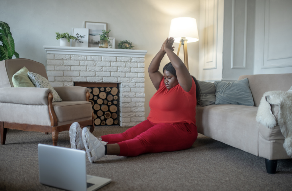 Plus size african american woman having an online yoga class