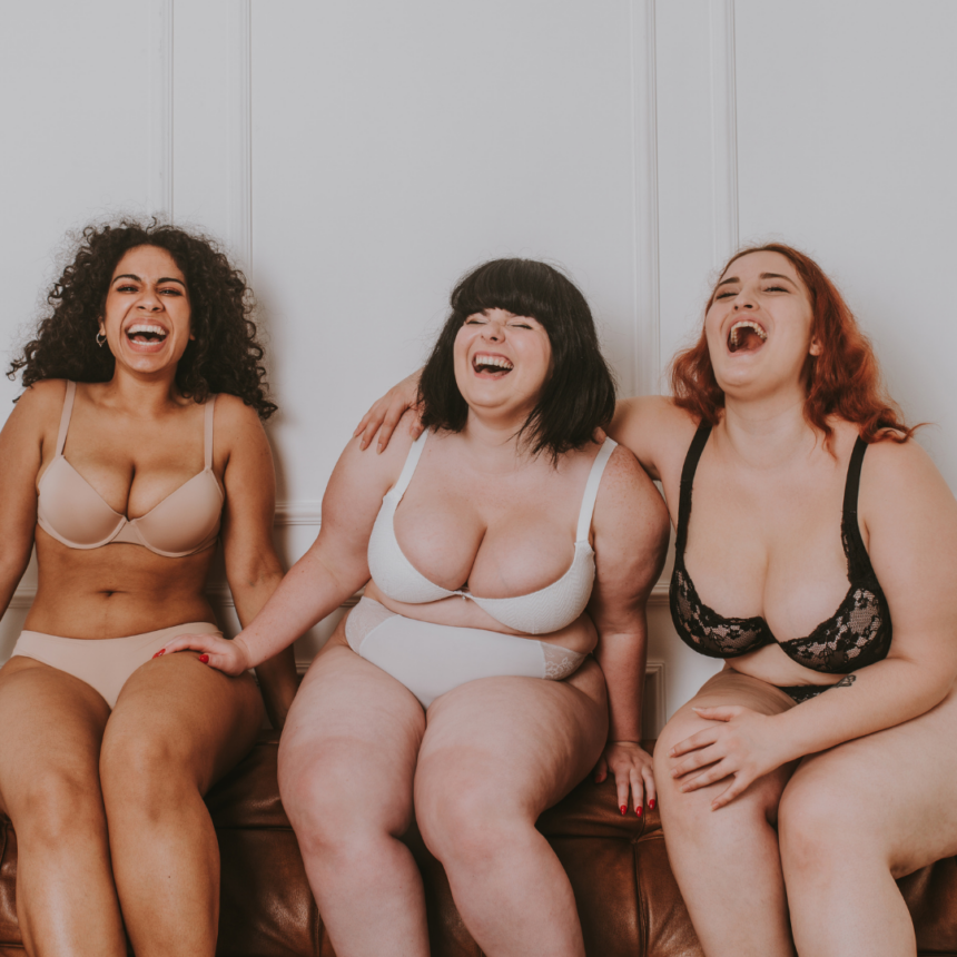 Three plus size women laughing happily