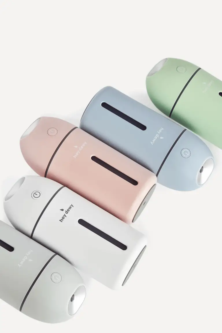 Five Hey Dewy facial humidifiers lay on a white background.