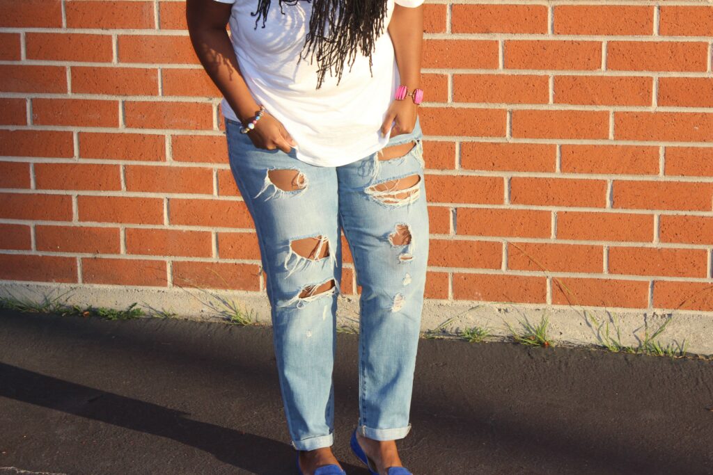 black woman in denim and white t shirt in front of brick wall for labor day sale