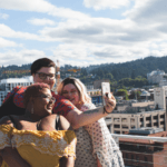 plus size black woman with short hair taking selfie with plus size woman with dark hair and plus size woman with blonde hair in front of a picturesque view