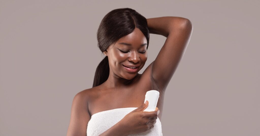 black woman using deodorant