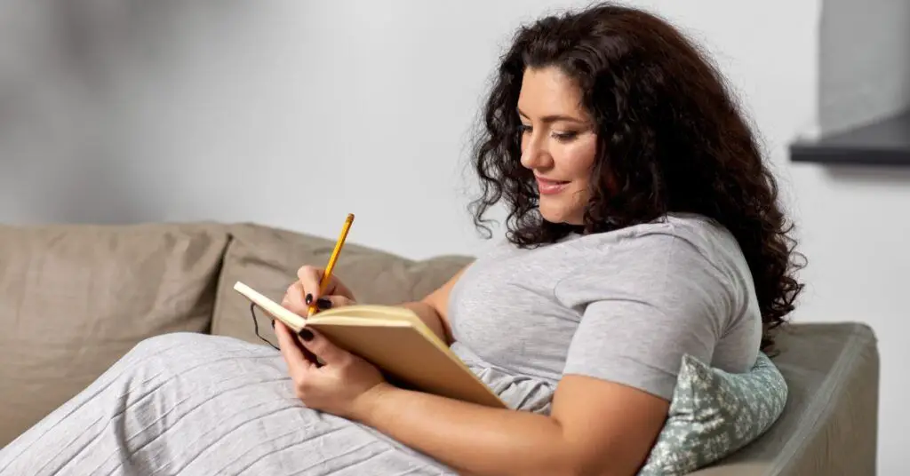 Plus size woman journaling- New Year's Theme vs Resolutions