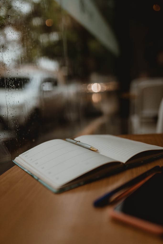 A cozy close-up of an open notebook and pen on a wooden table by a rainy window.

what I’m carrying into the new year
