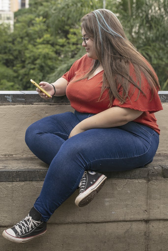 Side view of a plus size woman using a smartphone outdoors in São Paulo.