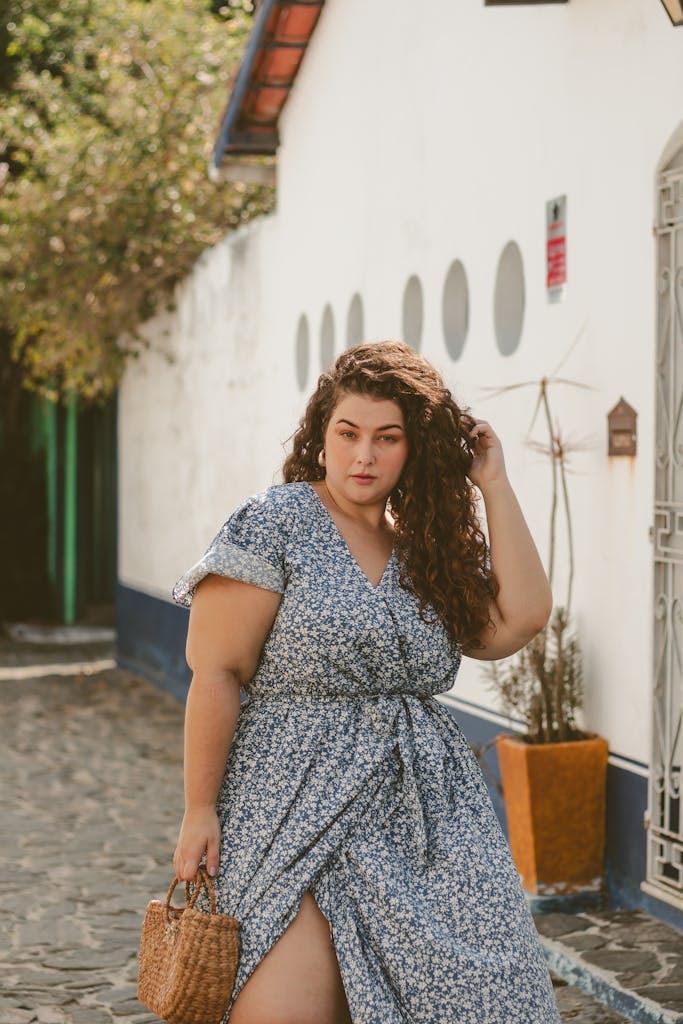 Stylish woman in a blue floral dress standing confidently outdoors in Rio de Janeiro.
posture tips for plus size women