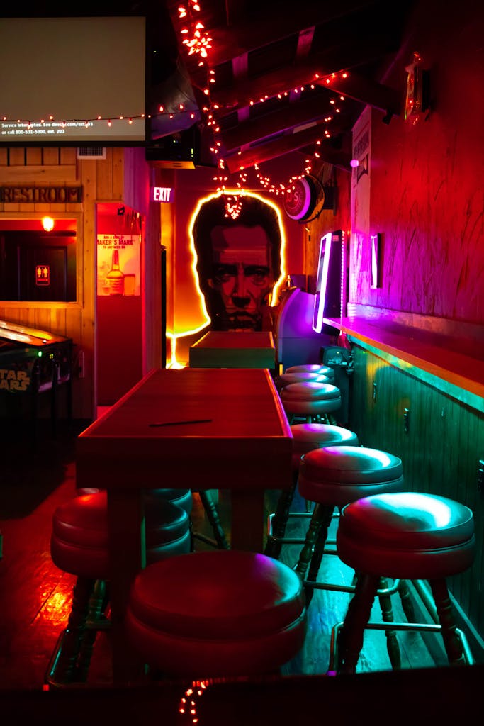 Vibrant neon-lit bar with artistic decor and empty seating, creating an inviting and modern atmosphere yet a tough invisible labor for plus size women.