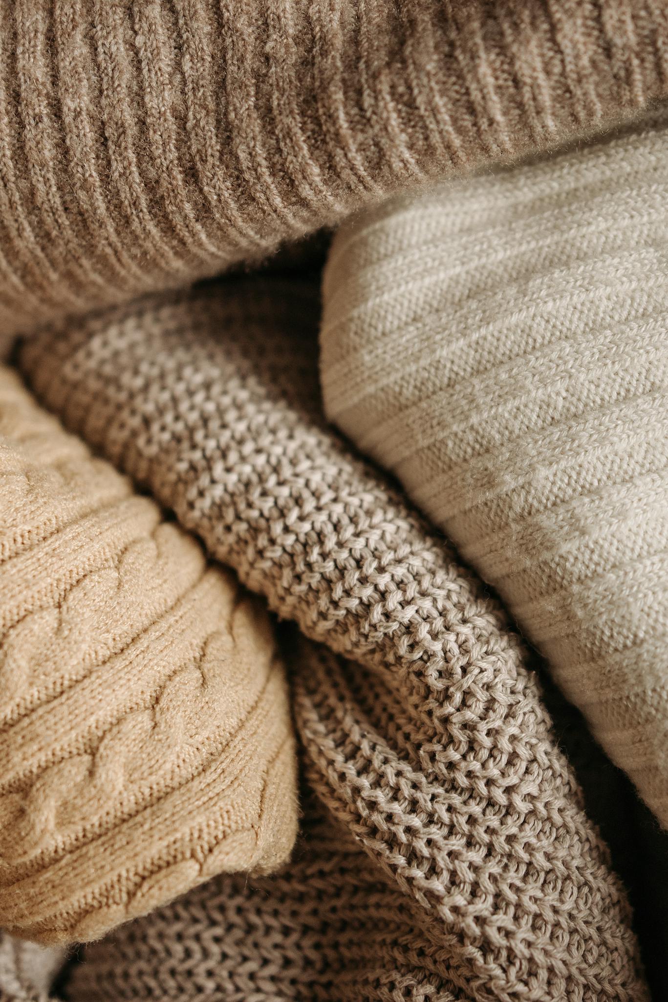 A detailed close-up of assorted knitted textiles showcasing different patterns and textures.