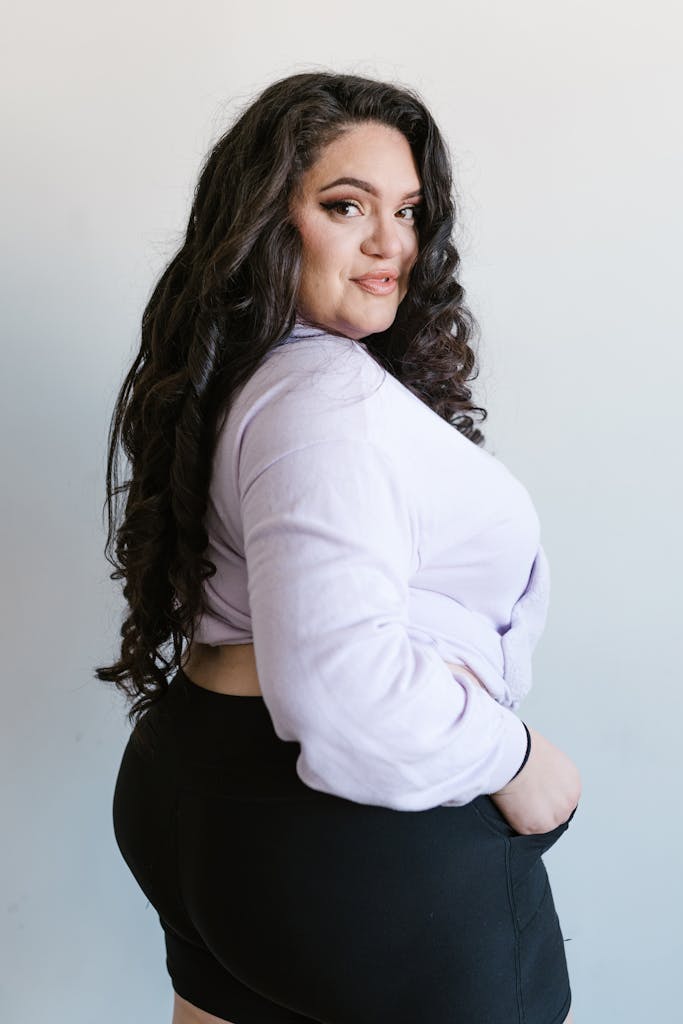 A plus-size woman poses confidently in casual wear, showcasing body positivity. showing plus size marketing strategies 