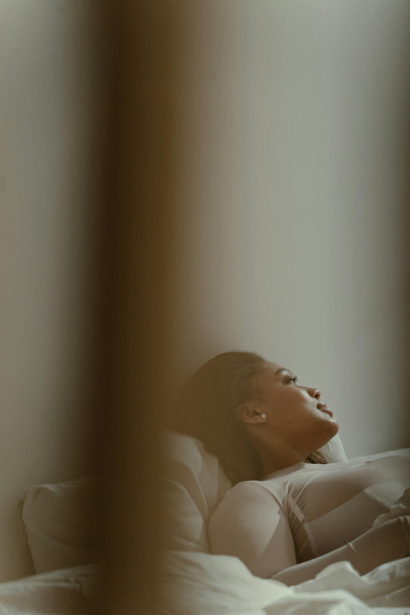 A serene image of a body positive plus size model lying indoors, showcasing relaxation.
radical self care for plus size people