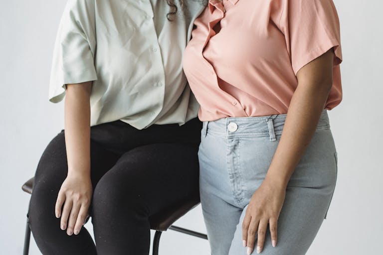 Close-up image of two women embracing in casual clothing, showcasing friendship and style.