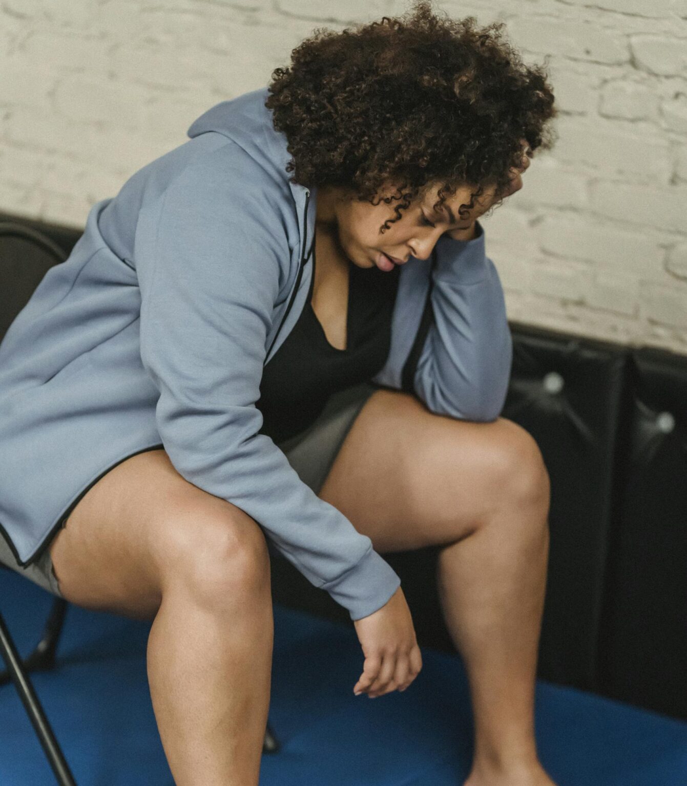 Full body of tired African American female in activewear sitting on chair near boxing gloves during workout in modern gym
plus size burnout signs