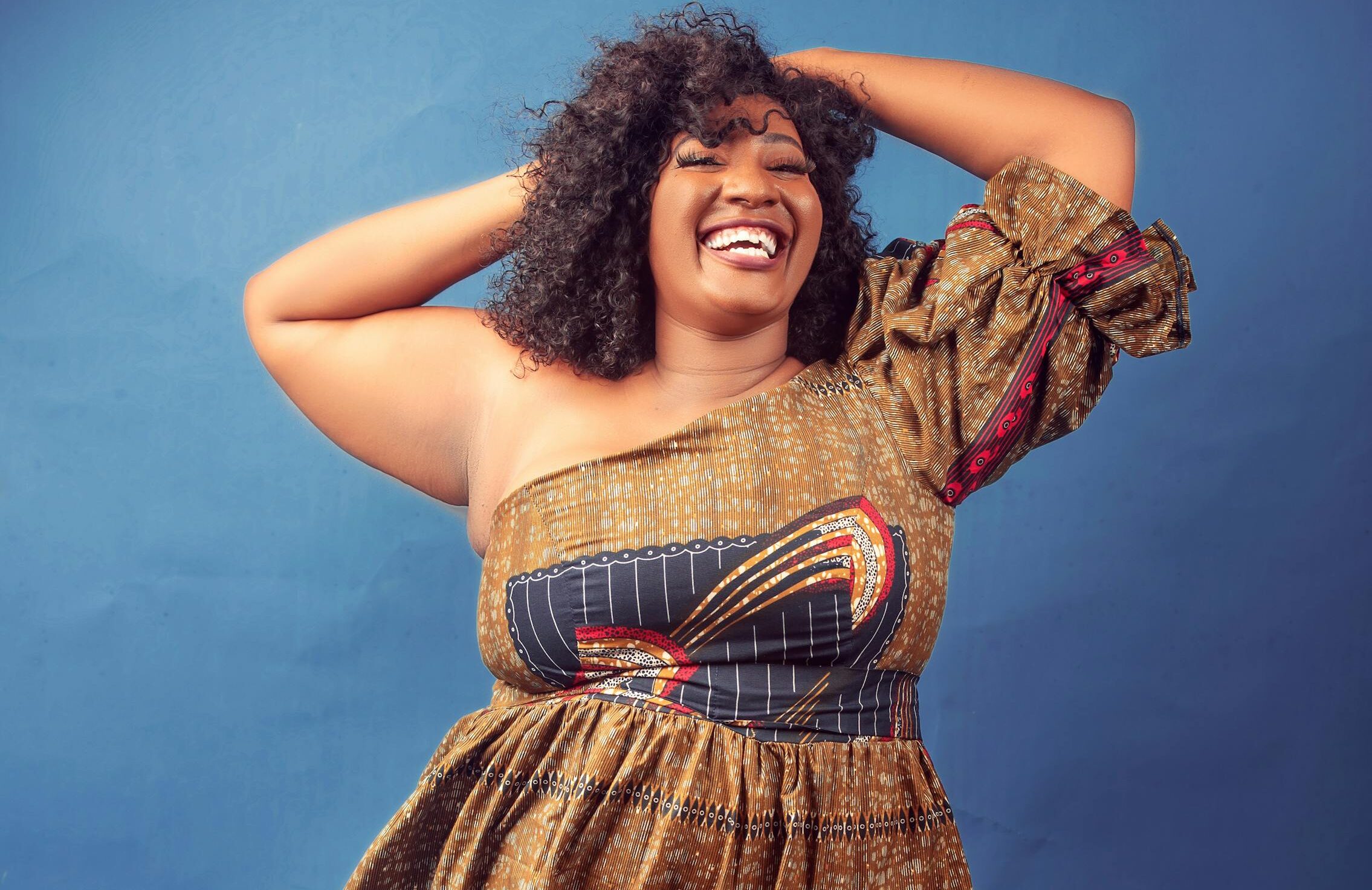 Joyful and confident plus-size woman in a colorful dress, exuding positivity and self-assurance.