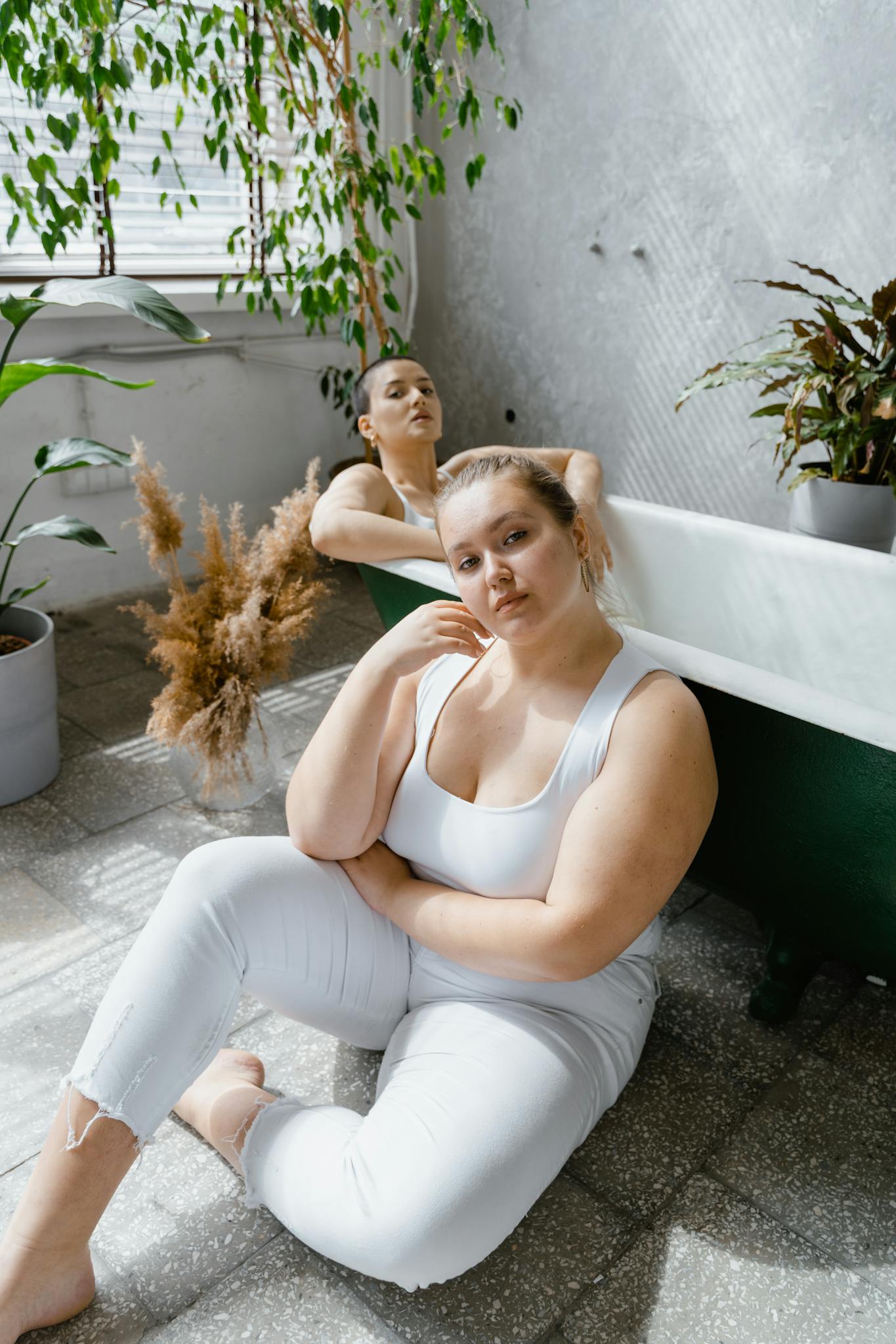 Portrait of diverse plus size women embracing self-esteem in a botanical bathroom setting.
radical self care for plus size people
