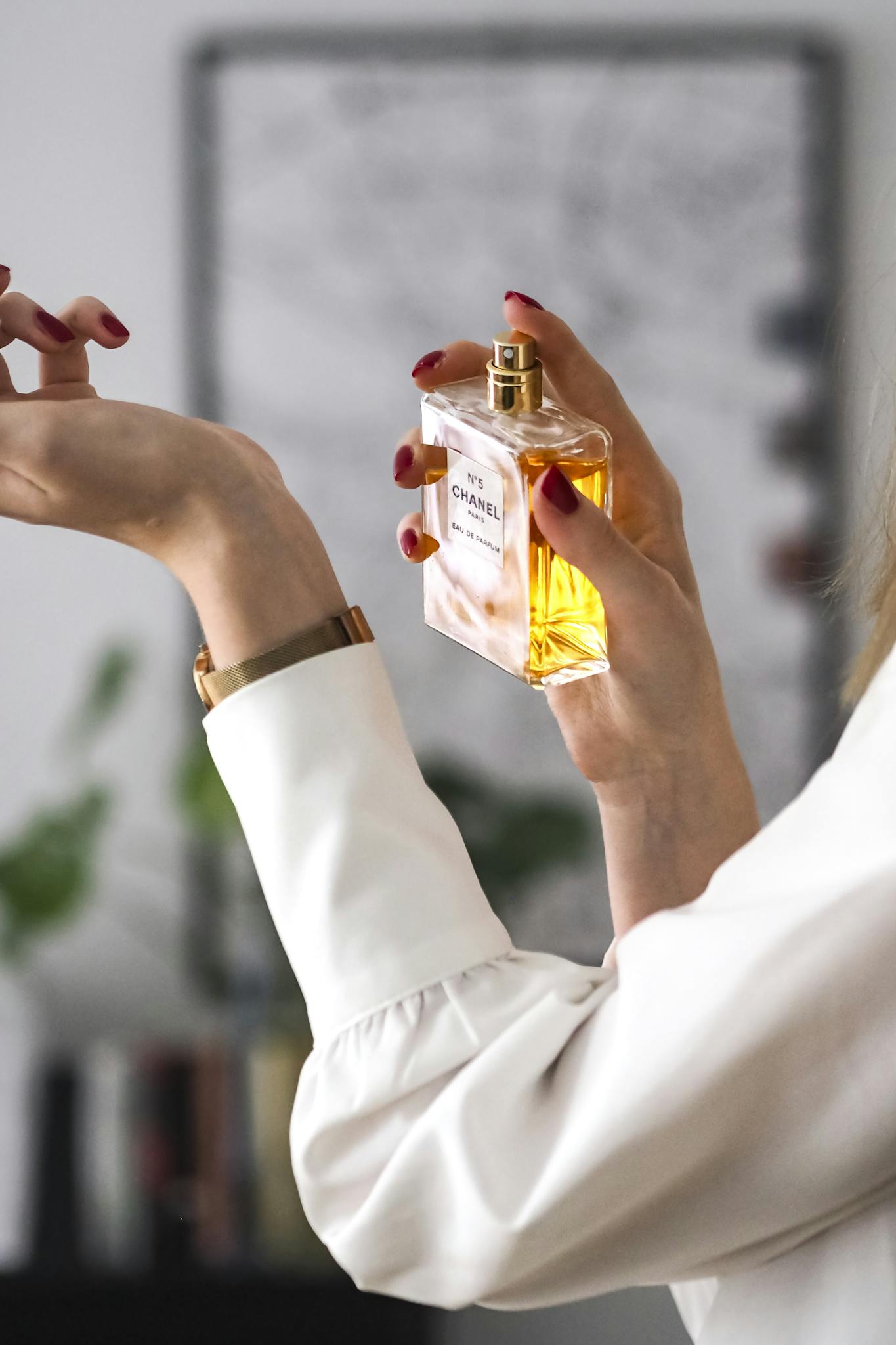 Close-up of a woman applying perfume on her wrist. Elegant and sophisticated.