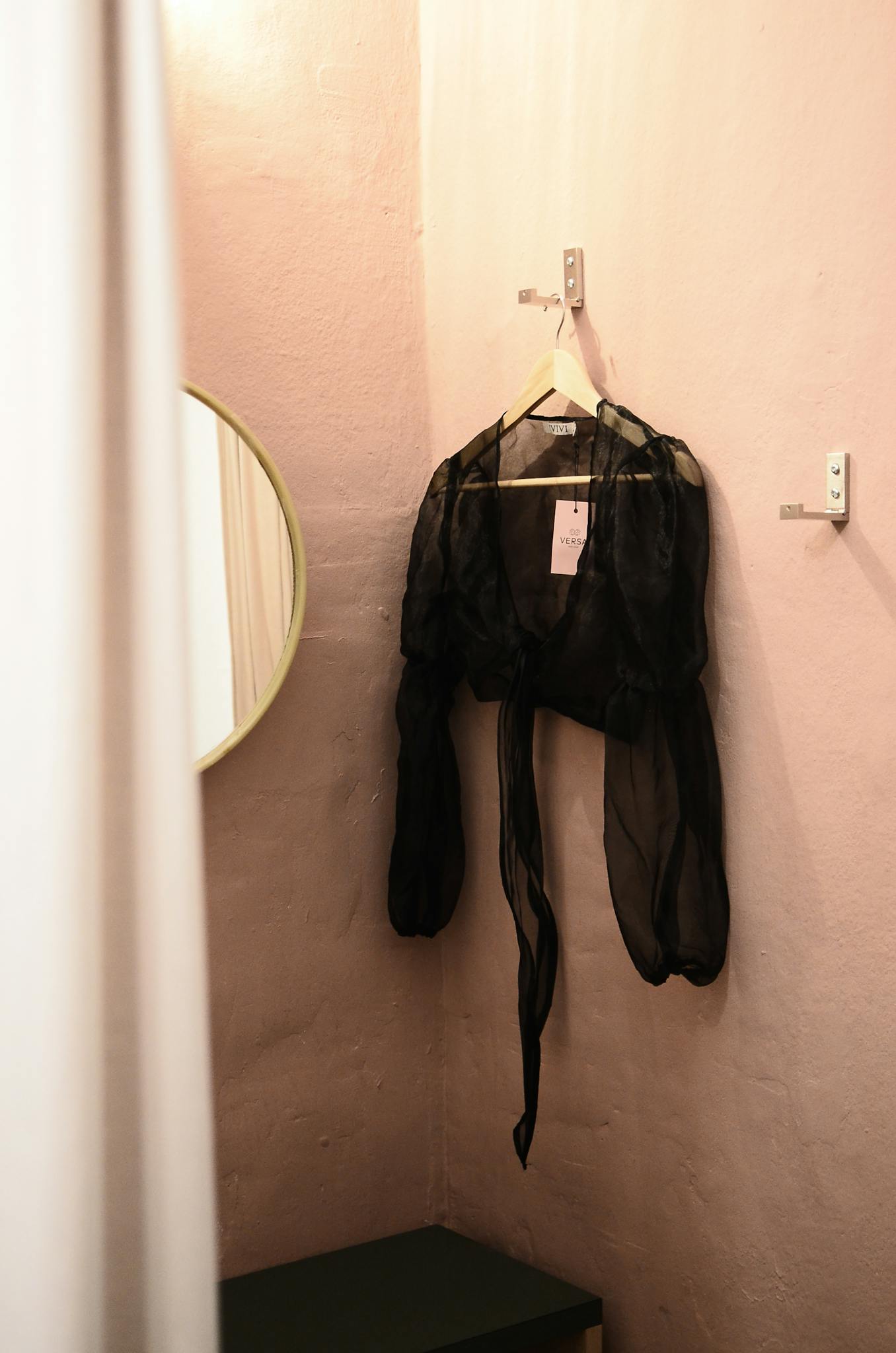 Interior of room for trying clothes on with mirror and blouse on wall

dressing room anxiety