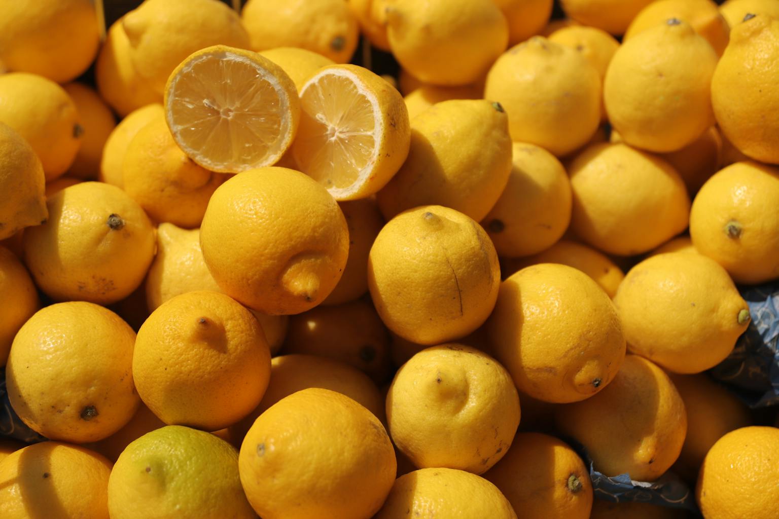 Vibrant organic lemons piled in a Sicilian market, showcasing freshness. how perfume notes work