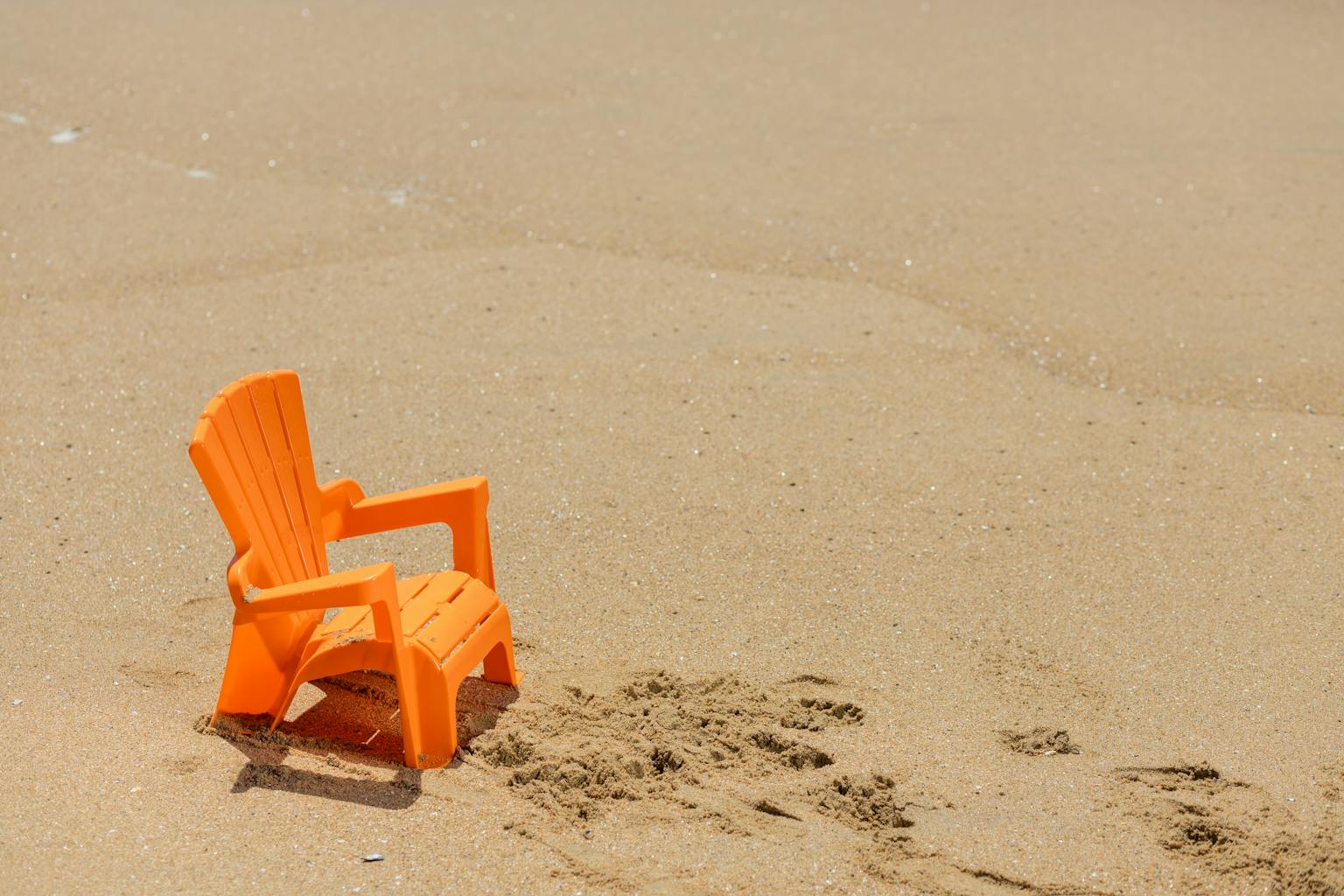 A vibrant orange plastic beach chair sits on a sandy shore under the sun, evoking a sense of tranquil seaside relaxation.

Beach Chairs for Plus Size