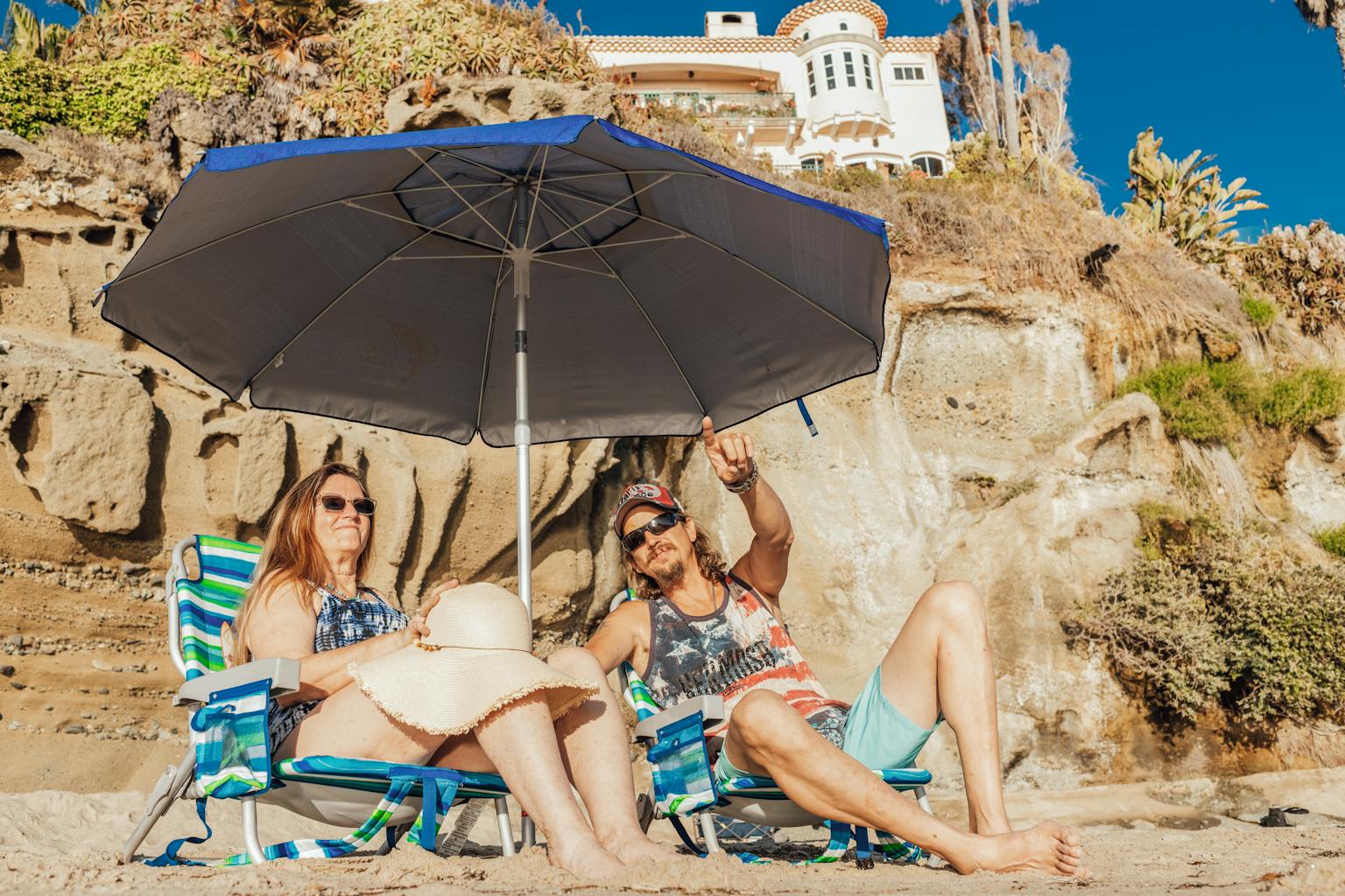 Senior couple lounges under beach umbrella on a sunny day, enjoying the coastal scenery.

Beach chairs for plus size people