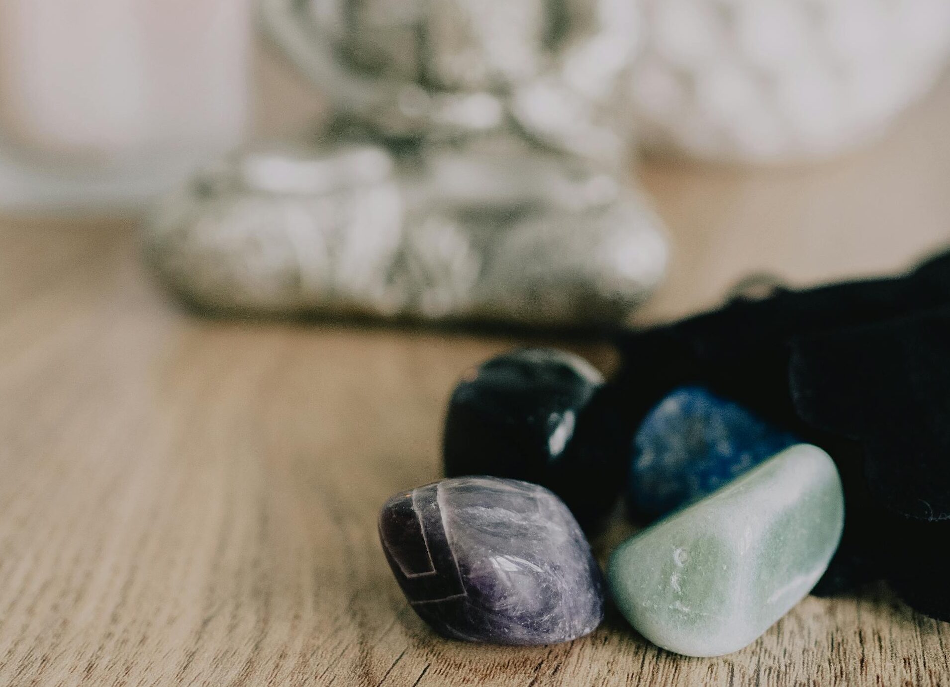 Serene Zen setup with healing crystals and a candle on a wooden table, promoting tranquility.