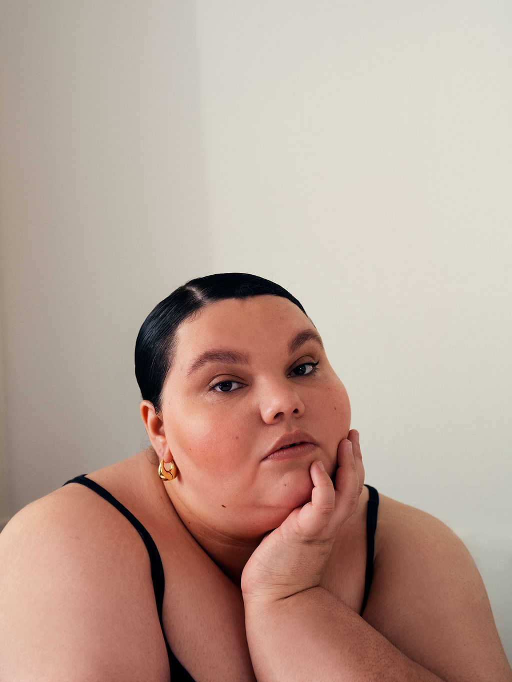 Kartanya Maynard posing during an editorial photoshoot wearing a black outfit with soft lighting..
kartanya maynard plus size representation
