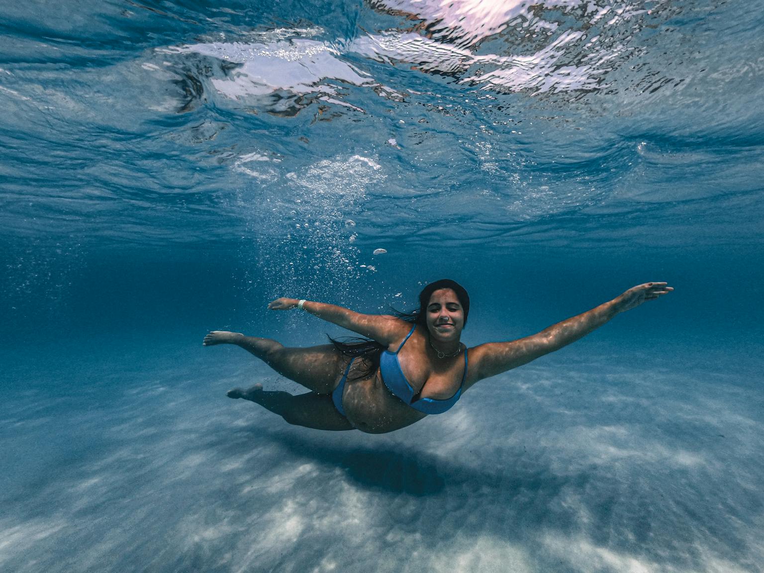 A woman swimming underwater in crystal clear ocean sea, creating a serene and vibrant scene.

Joyful movement