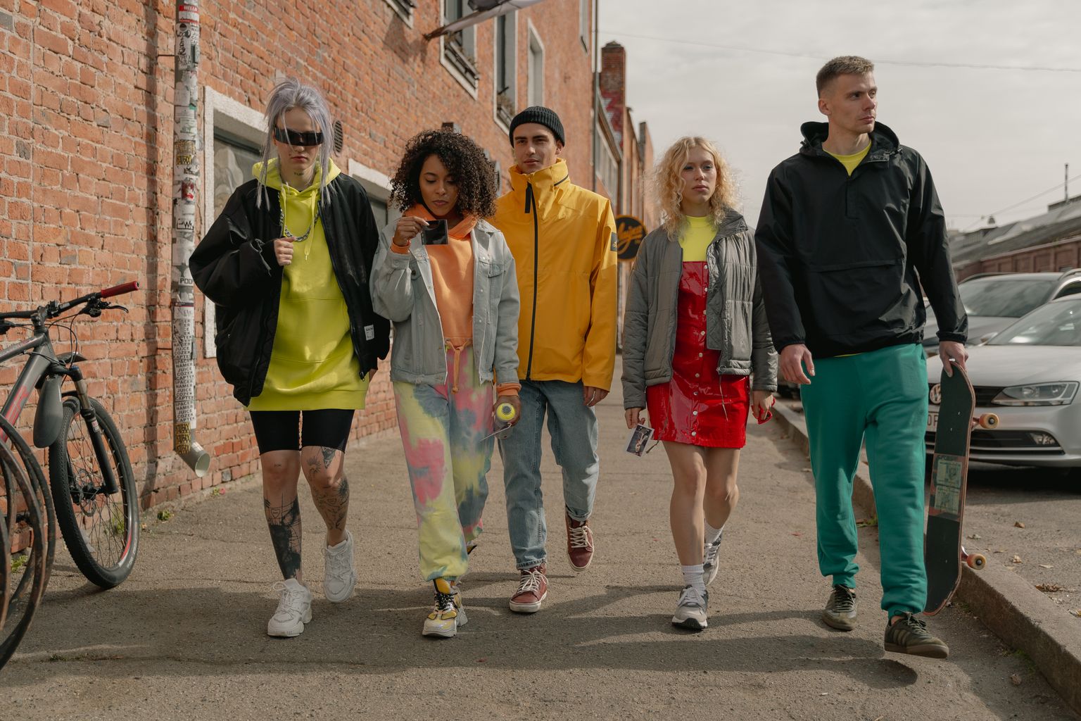 A group of stylish young adults walking together on a city street, showcasing modern fashion.