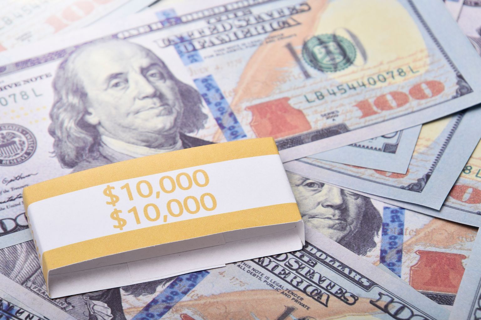 Close-up of $100 US dollar banknotes wrapped with a $10,000 band, symbolizing wealth and financial success.