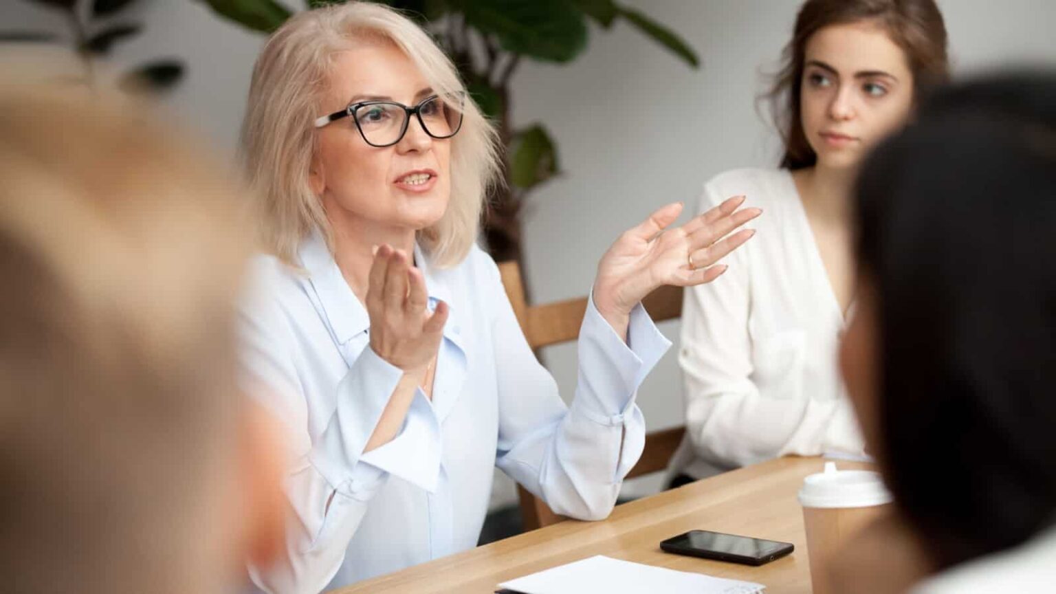 Businesswoman in meeting. Image credit fizkes via Shutterstock
