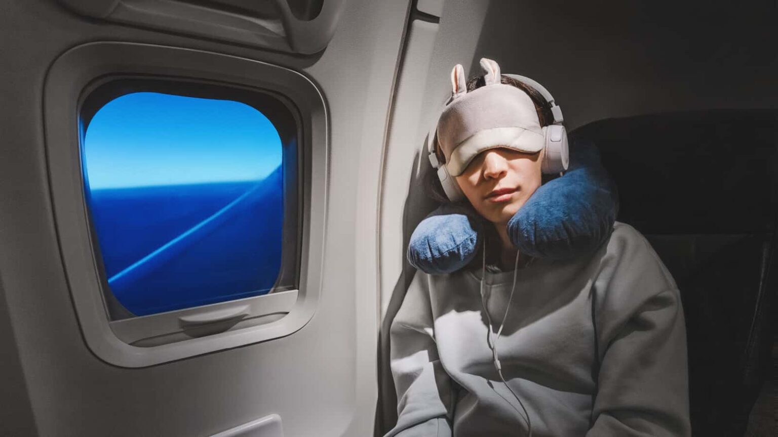Woman sleeping on plane at night. Image credit frantic00 via Shutterstock