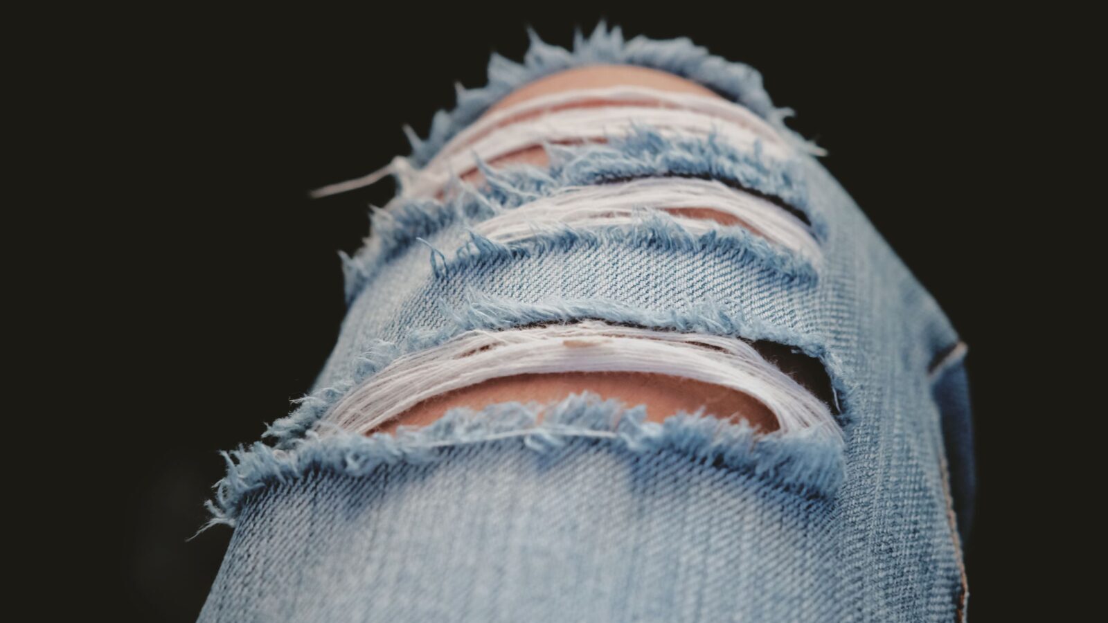 Detailed shot of torn denim jeans showcasing modern fashion and style.