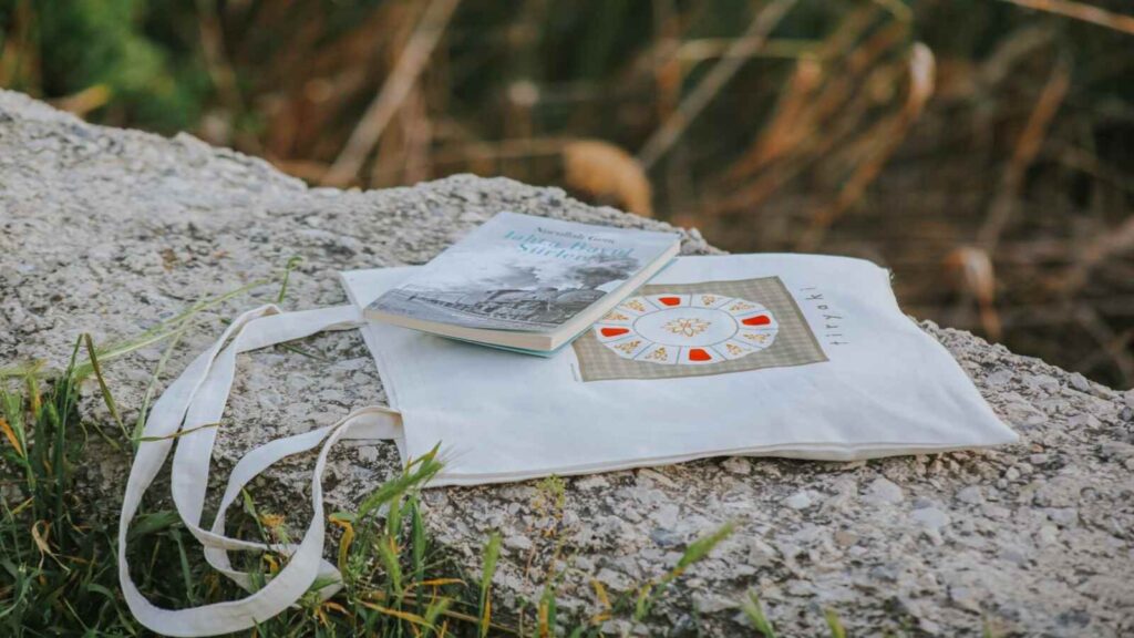 photobook and tote bag on a stone surface outdoors 34800392
