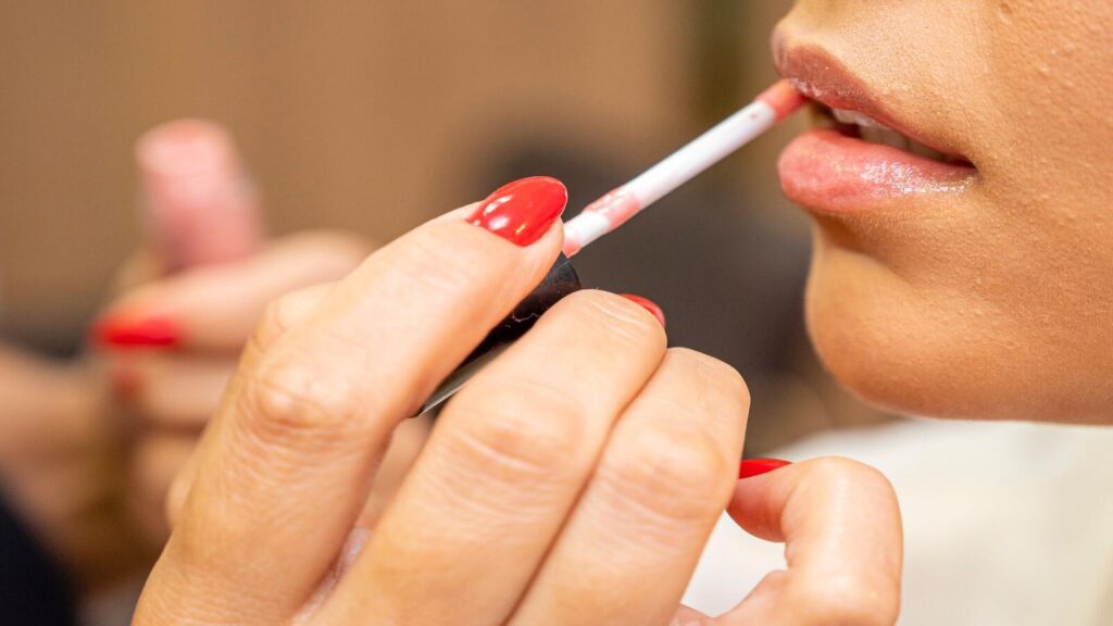 photoclose up photo of a person applying lipstick 10816496
