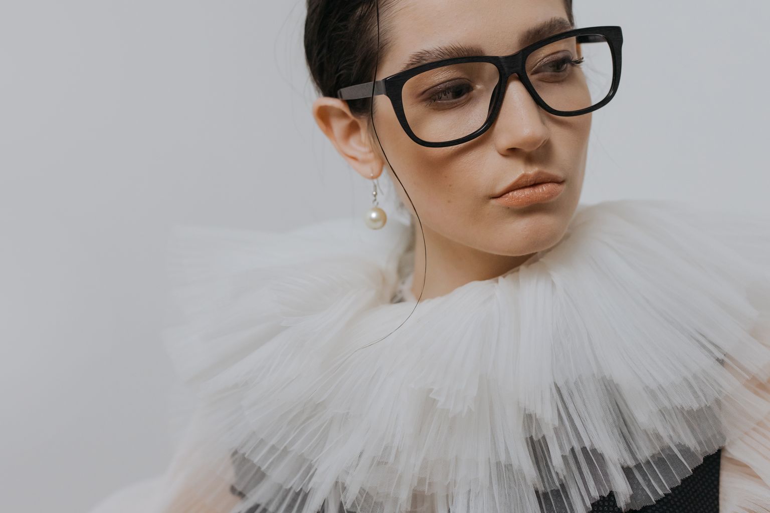 portrait of a stylish woman in a chiffon collar wearing glasses and a pearl earring. 6539156