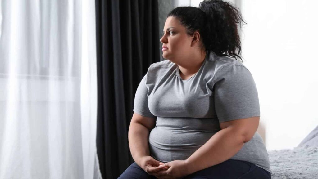 sad fat woman. New Africa via Shutterstock