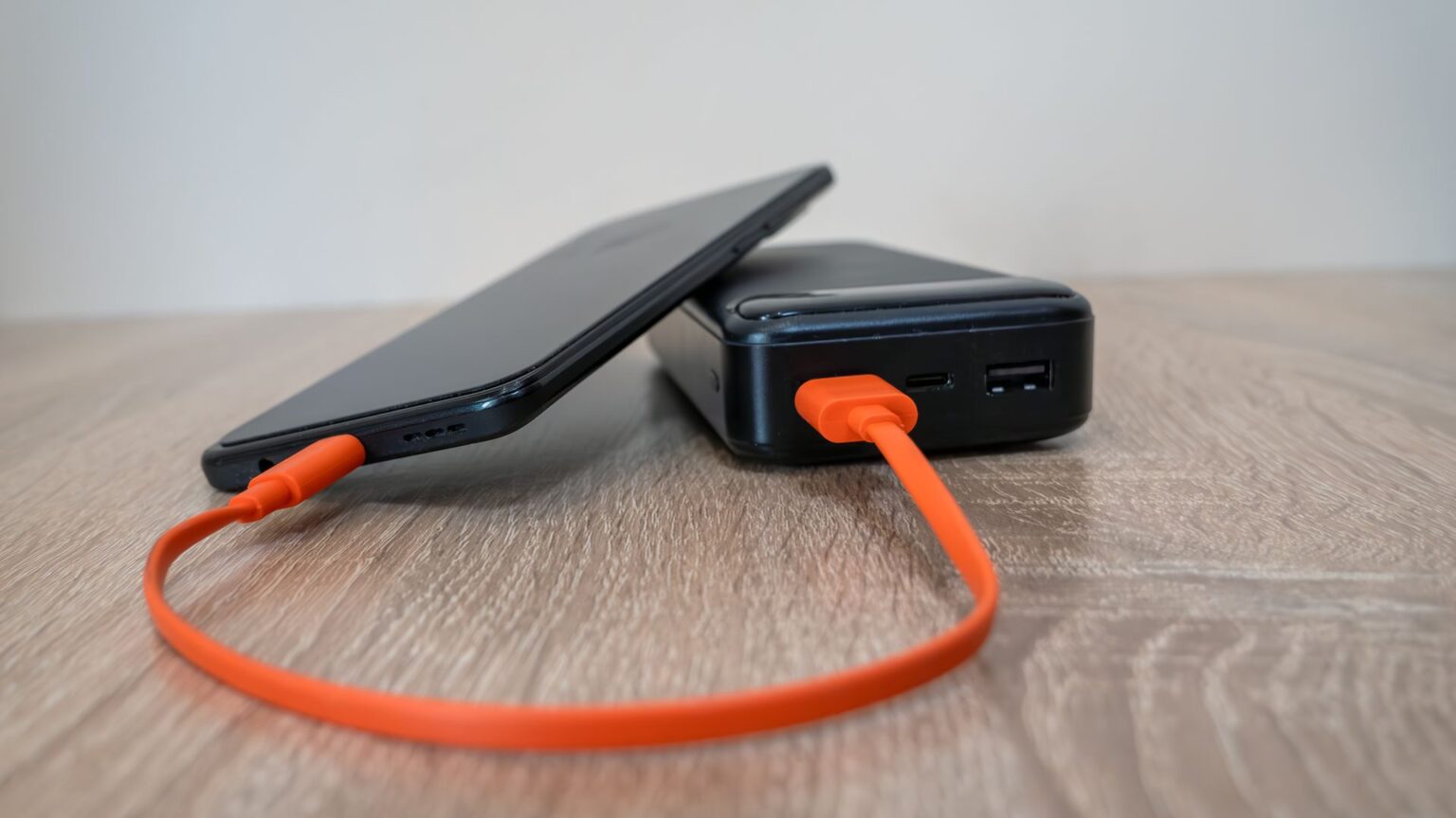 smartphone charging with power bank on wooden surface 37475662