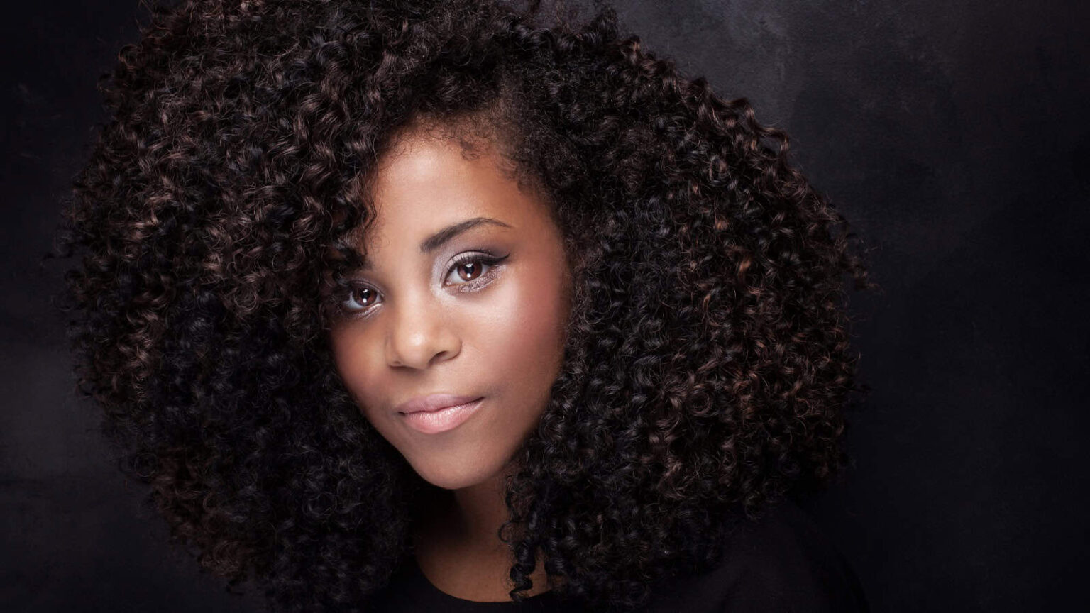 woman with curly hair. Image credit NeonShot via Shutterstock