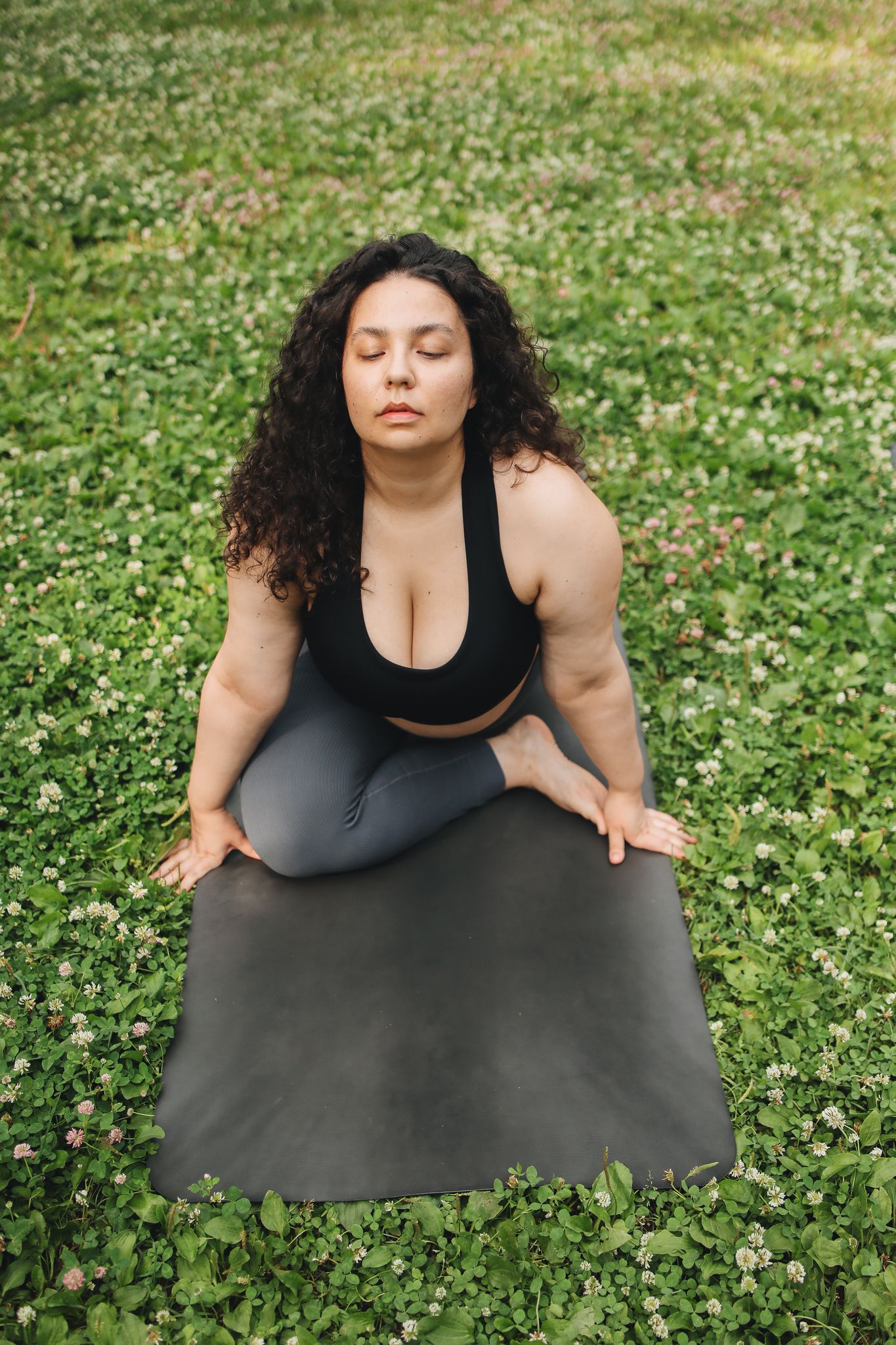 august horoscopes A woman practices yoga on a mat outdoors, promoting fitness and body positivity.