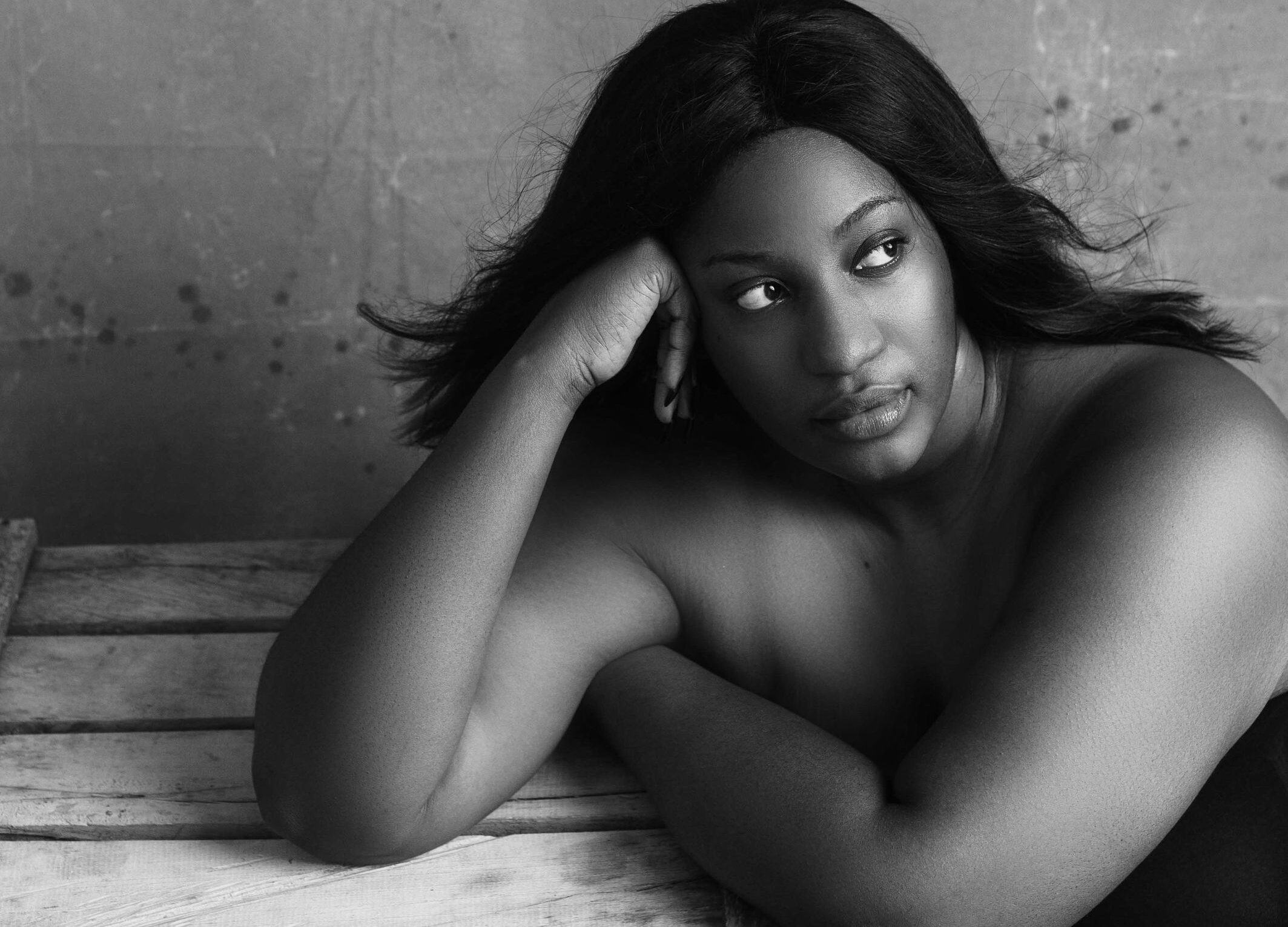 Black and white high angle of plump African American female with flowing hair thinking on problem and looking away